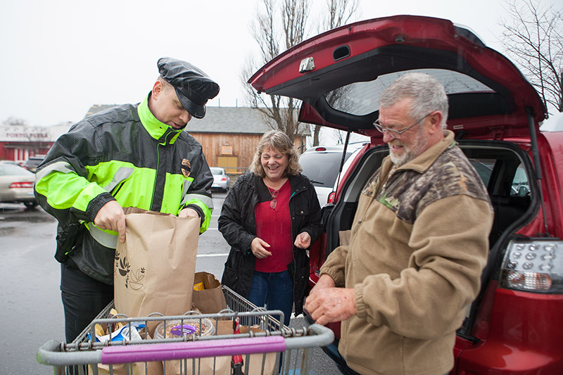 Tisbury Detective Max Sherman, left, helps unload groceries for Kim and Dennis.