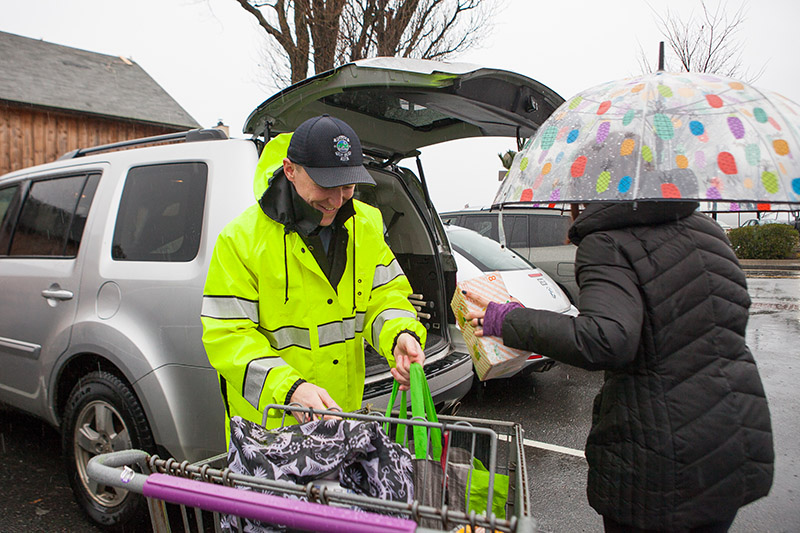 Tisbury Officer Michael Maliff unloads groceries for Cherish Harris.