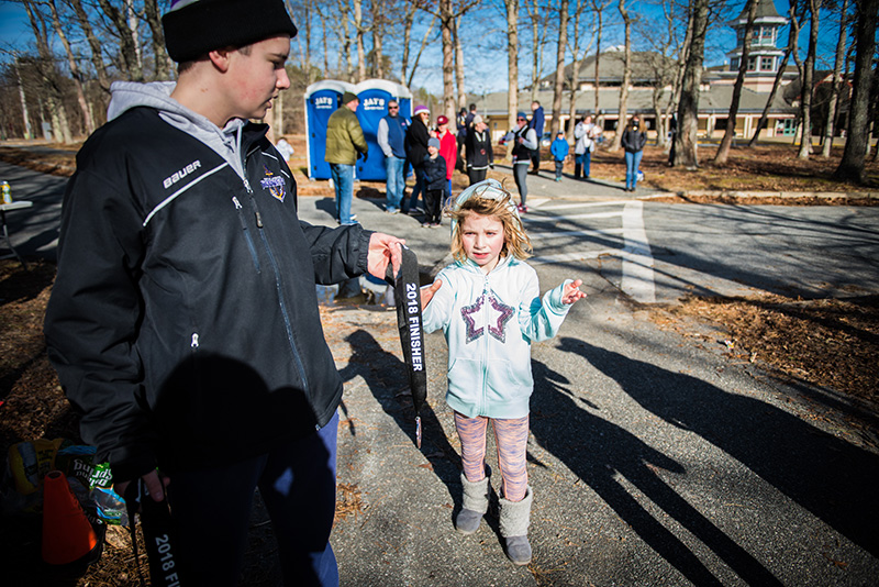 Hannah Kollett, 7, receives her medal at the finish line.