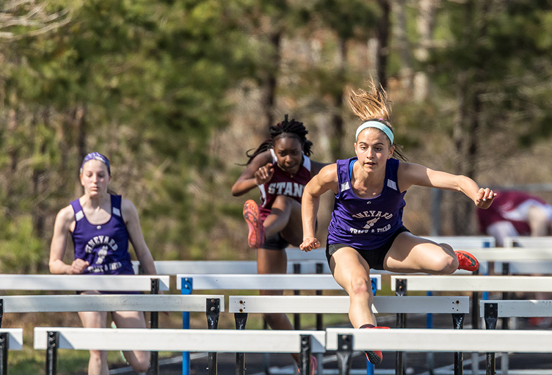 Mackenzie Condon, right, hurdles in the meet against Bishop Stang on Wednesday.