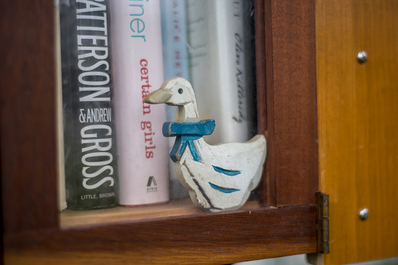 A wooden Mother Goose detail on the doors of the Little Free Library.