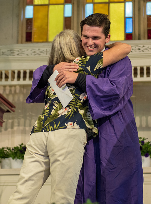 Sean O’Malley is hugged by the presenter after receiving a scholarship.