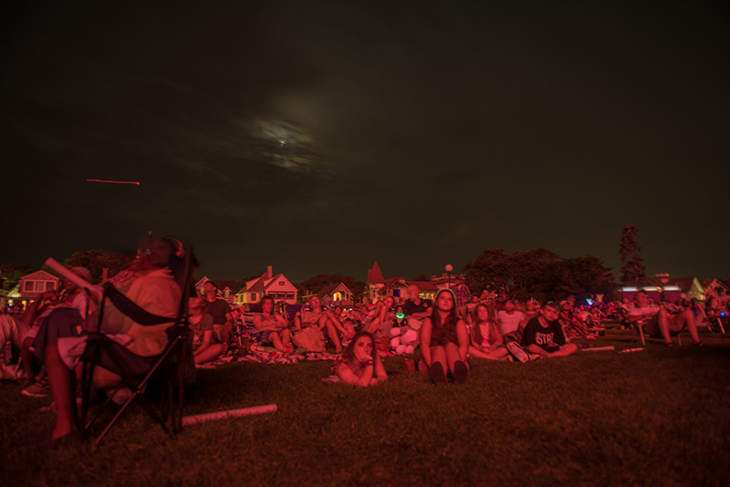 The crowd illuminated by the firework’s glow.