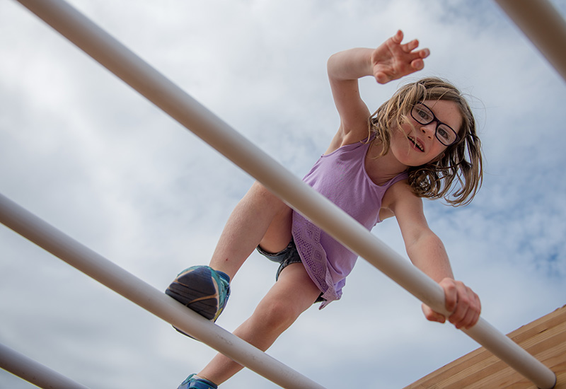 Annalee Wike, second grade, climbes the arched monkey bars during recess.