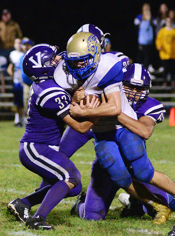 Andres Garcia (left) and Brian Torres wrap up QB Mike Satkevich.