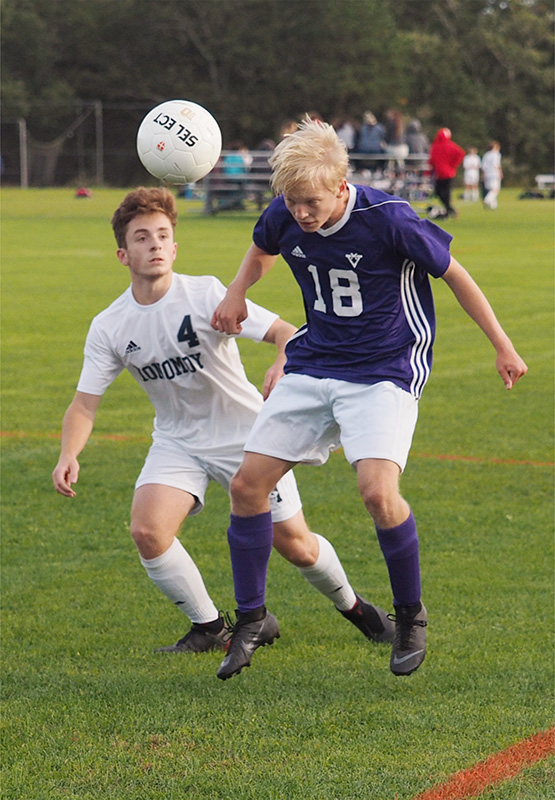 Fynn Monahan heads the ball away from Connor Coughlan.