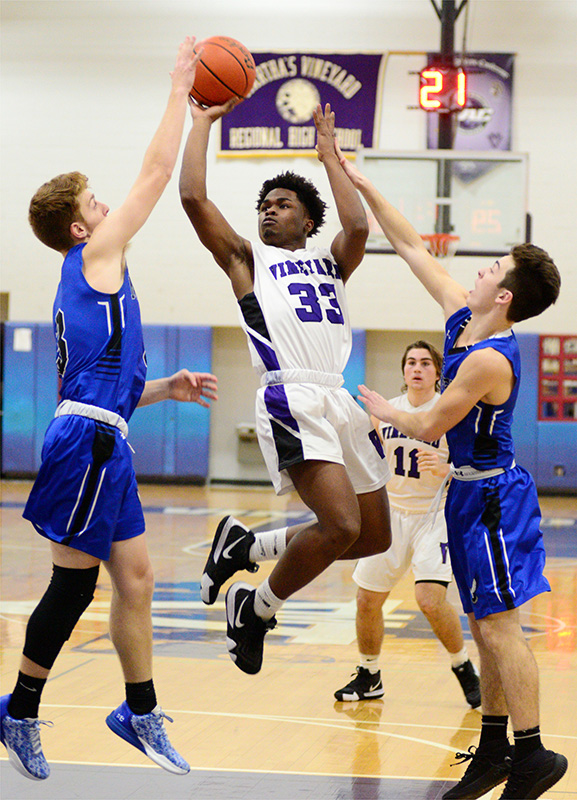 Dylan Dyke goes up for a shot between a pair of Falcon defenders.