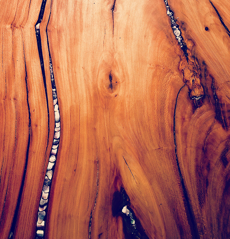 A wood table with Island oriented- stone and wampum.
