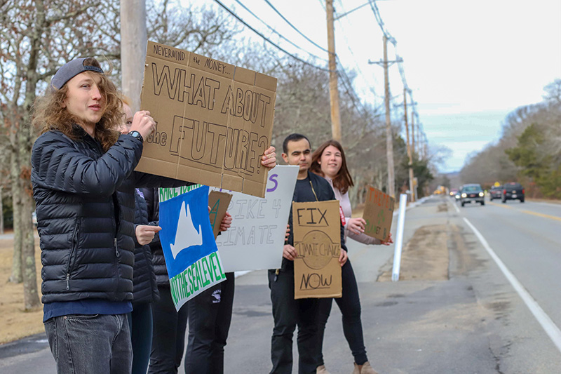 Kieran Karabees grabs the attention of passing drivers with his sign.