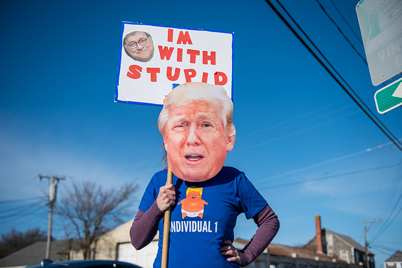 Carla Cooper stands with her Donald Trump head sign at Five Corners.