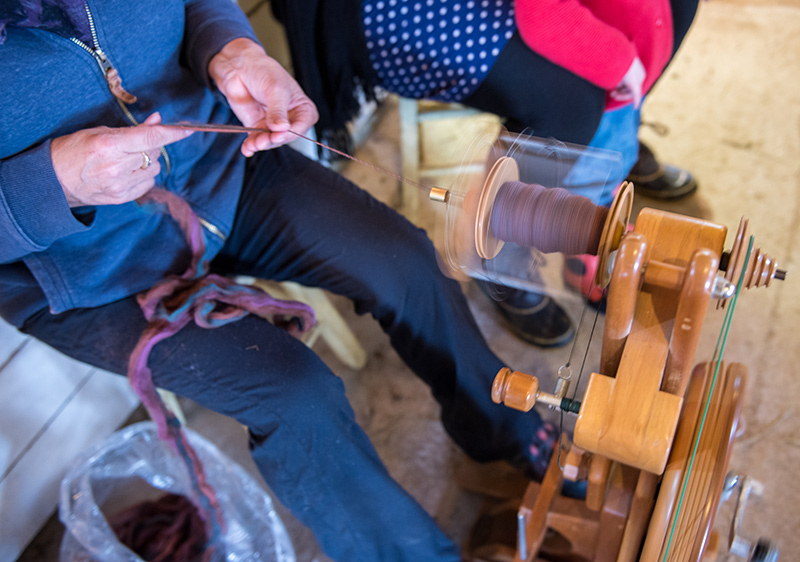 Nicola Blake demonstrates wool spinning.