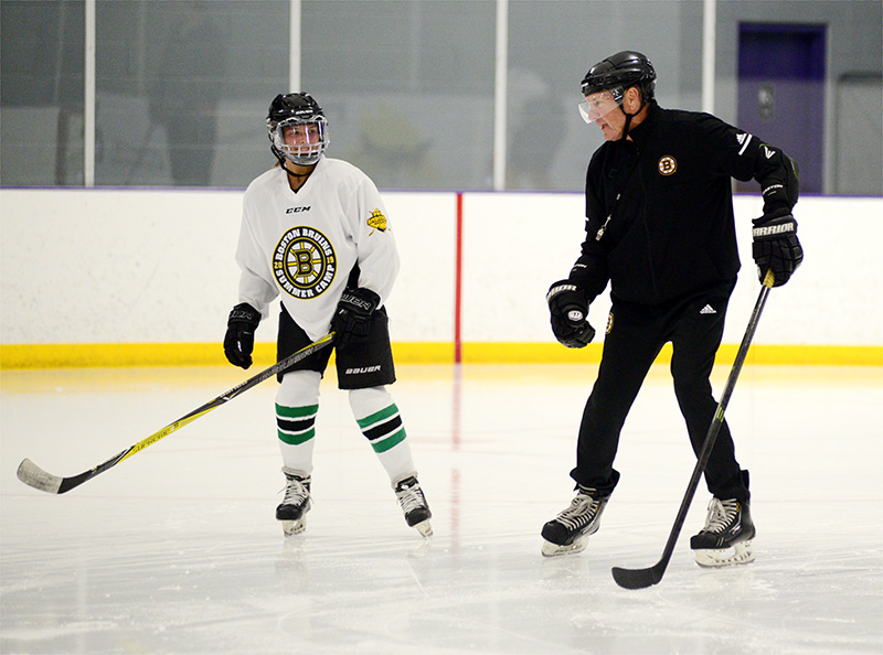 Marin Gillis works on her backwards skating with former Bruin Tom Songin.