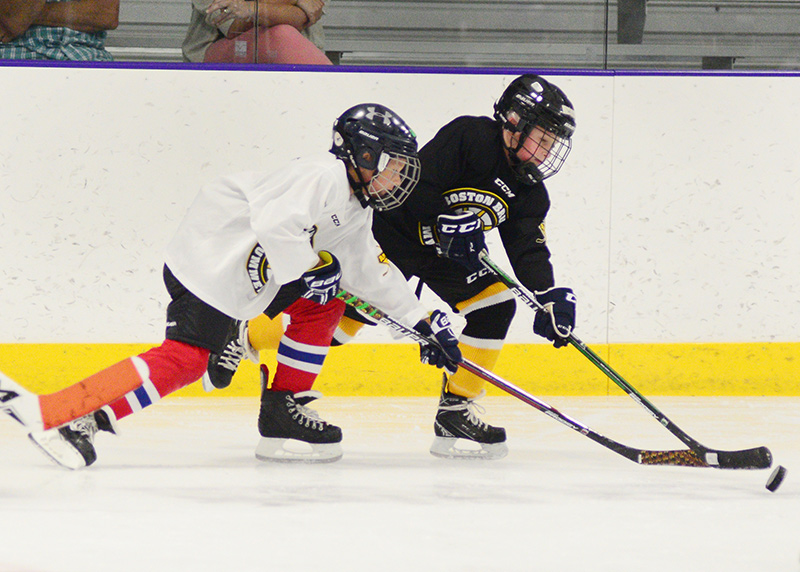 Young skaters battle for the puck in game simulation play.