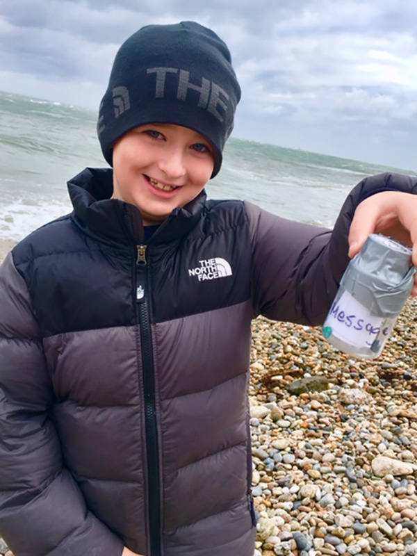 Joey Ragosta holding up the message in the bottle on Marble Beach.