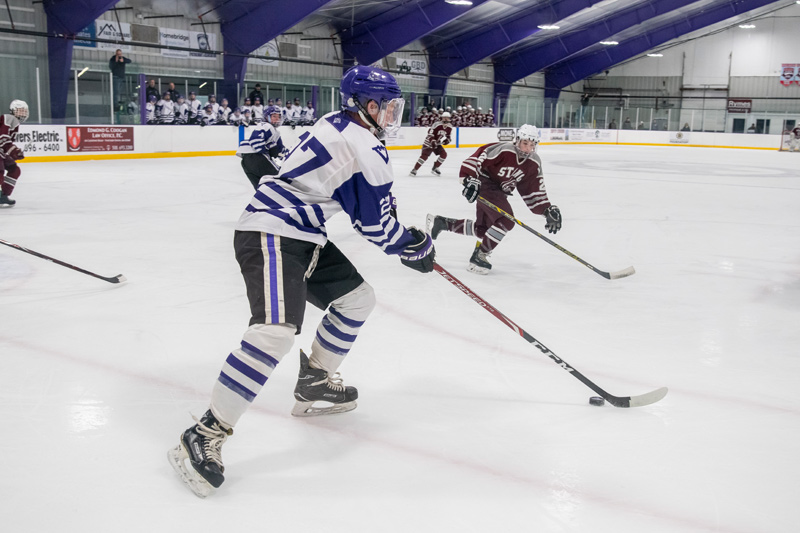 Senior Hoffman Hearn skates the puck away from the vineyard end.