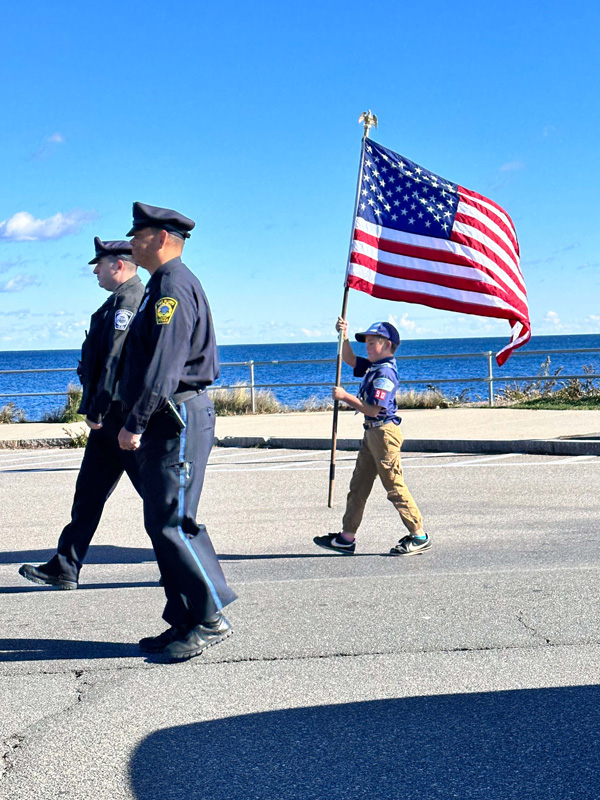 Buddy Noonan carrying a flag as part of the Veterans Day parade on Saturday.