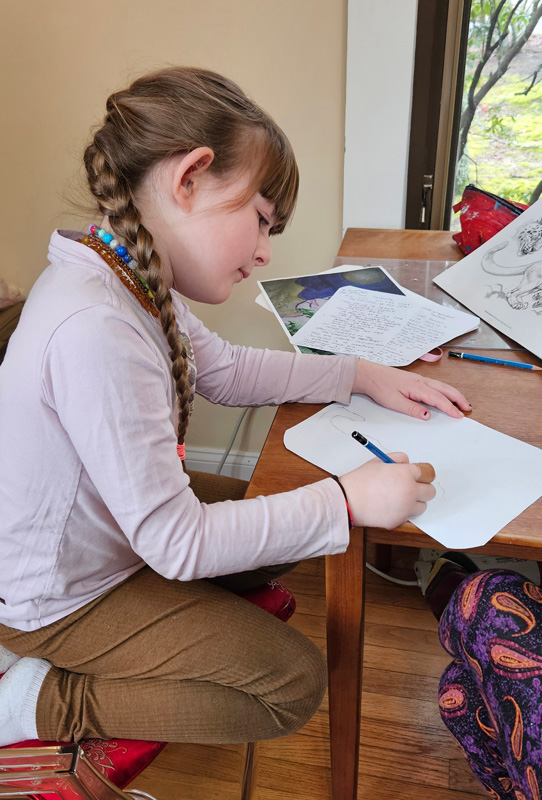Reagan sketching a snow leopard. Photo cred.