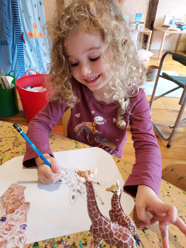 Madeleine working on her Giraffe sketch. Photo cred.