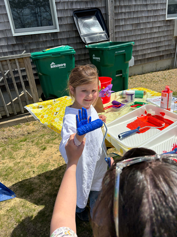 Jaylen getting her hand prepped for the painted hand tree painting.