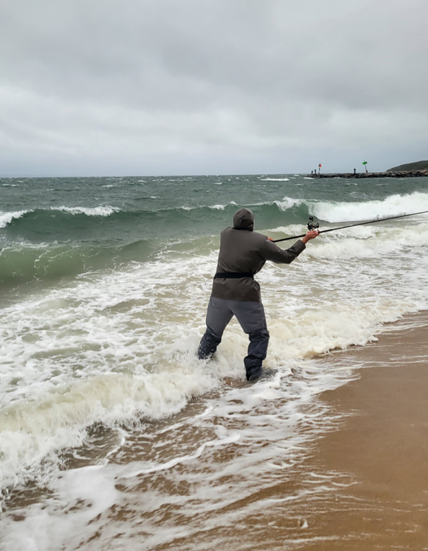 Oliver Valdes casting into 30 mph winds and pelleting rain at Lobsterville.