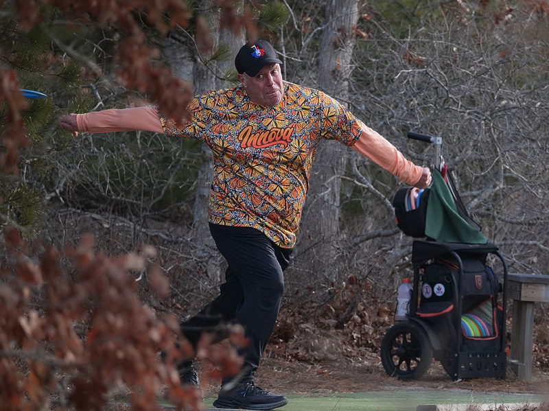 Disc golfer throws from the tee box.